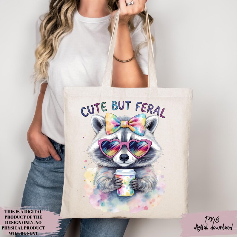 May include: A cream tote bag with a raccoon illustration wearing heart-shaped sunglasses and a bow, holding a coffee cup. The text "CUTE BUT FERAL" is above the raccoon. The bag is held by a person. The text "THIS IS A DIGITAL PRODUCT OF THE DESIGN ONLY. NO PHYSICAL PRODUCT WILL BE SENT" is on the bottom left.