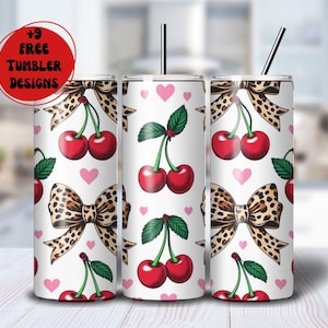 May include: Three white tumblers with a repeating pattern of red cherries, pink hearts, and leopard print bows. Each tumbler has a black straw. The text "+9 FREE TUMBLER DESIGNS" is in a red circle.