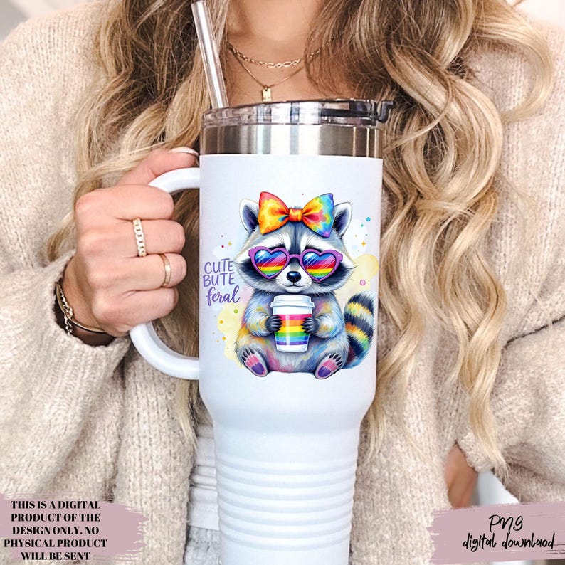 May include: White tumbler with a cartoon raccoon wearing rainbow heart-shaped sunglasses and a bow, holding a rainbow coffee cup. The text "CUTE BUTE feral" is on the tumbler. It has a silver lid and a handle. The image is a digital download.