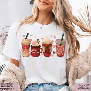 May include: White t-shirt featuring a crochet design of four coffee drinks with heart accents. One mug says "true love". The design includes pink, red, and brown colors. The text on the bottom left says "THIS IS A DIGITAL PRODUCT OF THE DESIGN ONLY. NO PHYSICAL PRODUCT WILL BE SENT".