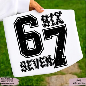 May include: White rectangular item with the words "SIX 67 SEVEN" in a black, distressed font. The item is held by a person. The bottom left corner reads "THIS IS A DIGITAL PRODUCT OF THE DESIGN ONLY. NO PHYSICAL PRODUCT WILL BE SENT." The bottom right corner reads "Png digital download."