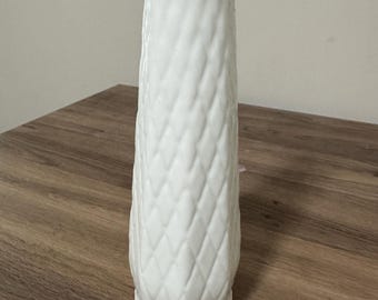 May include: White ceramic vase with a diamond pattern.