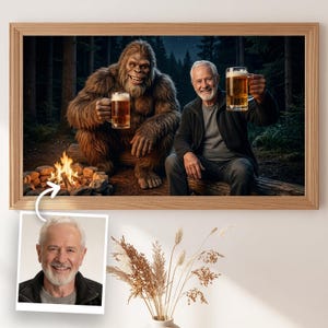 Könnte beinhalten: Ein gerahmter Druck zeigt einen Mann und einen Bigfoot, die in einer Waldszene mit Bierkrügen anstoßen. Ein Lagerfeuer brennt im Vordergrund. Der Druck ist in einem Holzrahmen und enthält ein kleineres Foto des Mannes.