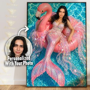 May include: A framed print featuring a person dressed as a mermaid, lounging on a pink flamingo pool float in a pool. The mermaid costume is pink and iridescent, with seashell and pearl accents. The image includes a personalized photo.