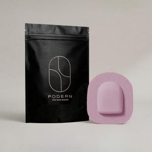 May include: Black pouch with a zipper and the word "PODERN" in white, with a geometric design. Next to it is a light purple medical device with a rounded rectangular shape and a light purple adhesive patch.