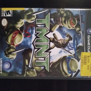 May include: Teenage Mutant Ninja Turtles video game case for the Nintendo GameCube. The case is black with a green and white logo. The front of the case features the four turtles in action poses. The game is rated "E" for Everyone by the ESRB.