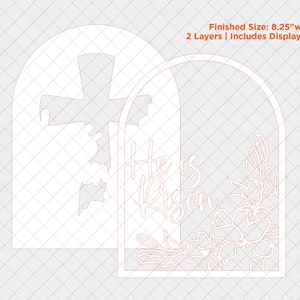 May include: A white, laser-cut, two-layer, wooden sign with an arched top. The sign features a cross on the left side and the words "He is Risen" on the right side. The right side also features a floral design with lilies. The sign is 8.25 inches wide and 11 inches tall.