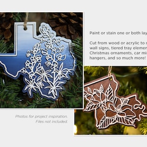 May include: Two laser cut wooden ornaments shaped like the state of Texas. One ornament is painted blue with white flowers and the other is stained brown with white flowers. The ornaments are hanging on a Christmas tree.