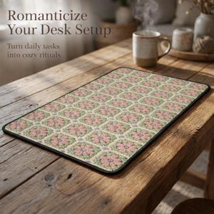May include: A rectangular desk mat with a floral pattern in pink, green, and beige. The mat has a black border and is placed on a wooden table. Text on the image reads "Romanticize Your Desk Setup" and "Turn daily tasks into cozy rituals."