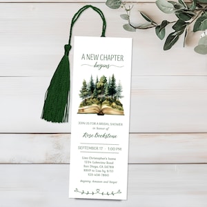 Può includere: Un segnalibro bianco con un nappa verde. Il segnalibro presenta il testo "A New Chapter Begins" e un'illustrazione di una scena di foresta che emerge da un libro aperto. Ulteriore testo annuncia un addio al nubilato per Rose Bookstone.