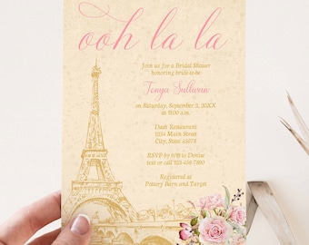 May include: A pink and gold bridal shower invitation with a sketch of the Eiffel Tower and floral accents. The invitation reads "ooh la la" and includes the bride-to-be's name, Tonya Sullivan, the date and time of the shower, the location, and RSVP information. The invitation also states that the bride-to-be is registered at Pottery Barn and Target.