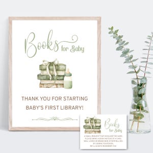 May include: A framed sign with the text "Books for Baby" and a watercolor illustration of stacked books, a bottle, and a bow. The sign also includes the text "Thank you for starting baby's first library!" A smaller card with the same design is also present.