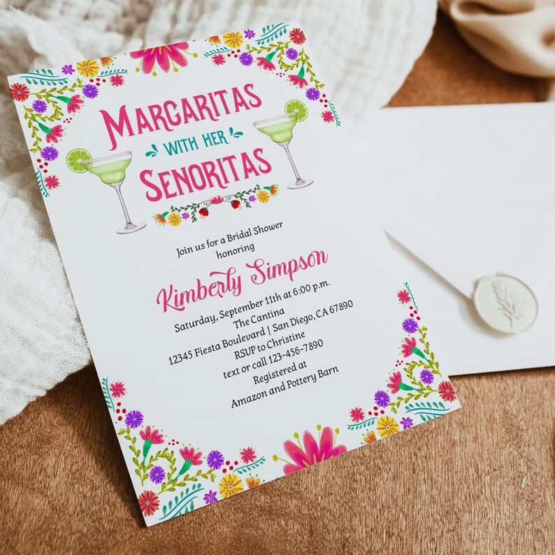 Op de afbeelding: Een witte bruidsdoucheinvitatie met een bloemige rand. De uitnodiging bevat de tekst "Margaritas with her Senoritas" en details voor een bruidsdouche voor Kimberly Simpson. De uitnodiging bevat de datum, tijd, locatie, RSVP-informatie en registratiegegevens.