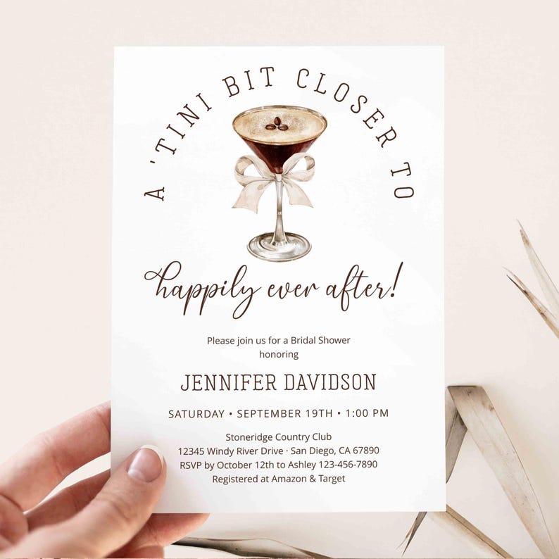 Puede incluir: Una tarjeta de invitaci&oacute;n blanca con el texto "A 'Tini Bit Closer To Happily Ever After!" presenta una ilustraci&oacute;n de acuarela de una copa de martini con un lazo. Los detalles incluyen el nombre de la novia, la fecha, la hora y el lugar.