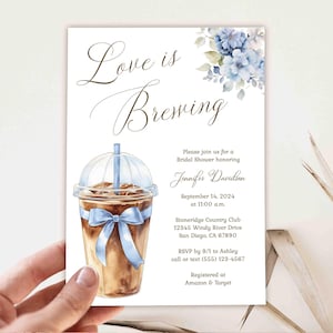 Pode incluir: Um convite para um chá de panela com uma ilustração em aquarela de uma bebida de café com uma fita azul. O texto diz "Love is Brewing" e inclui detalhes do evento, como a data, a hora, o local e as informações de RSVP.