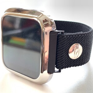 May include: A silver smartwatch with a black fabric band. The band has a silver buckle and a silver button with a logo.