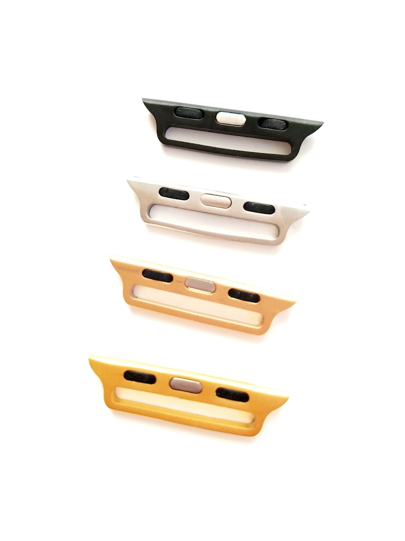May include: Four Apple Watch band adapters in different colors: black, silver, gold, and rose gold. Each adapter has a small button on the top.