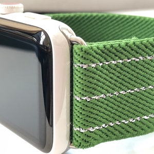 Puede incluir: Una banda de reloj Apple verde con costuras plateadas. La banda est&aacute; hecha de una tela tejida.