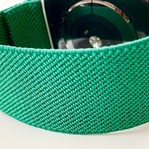 K&ouml;nnte beinhalten: Ein gr&uuml;nes gewebtes Apple Watch Armband mit einem strukturierten Muster.