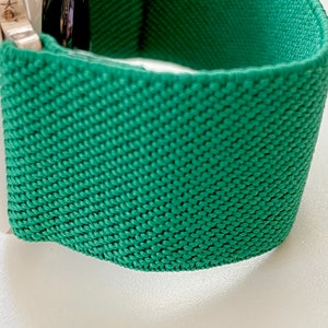 K&ouml;nnte beinhalten: Ein gr&uuml;nes gewebtes Apple Watch Armband mit einer strukturierten Oberfl&auml;che.