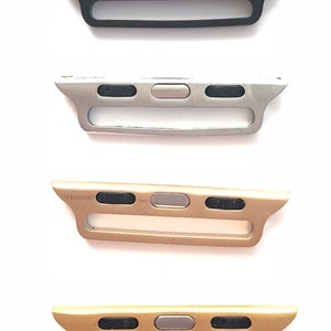 Puede incluir: Cuatro adaptadores de banda para Apple Watch en diferentes colores: negro, plateado, dorado y dorado rosa. Cada adaptador tiene tres botones negros y un bot&oacute;n plateado en el centro.