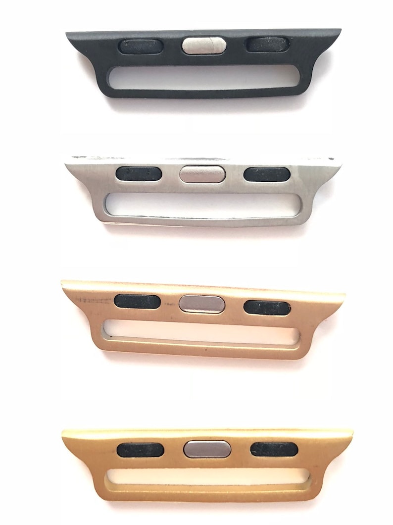 Puede incluir: Cuatro adaptadores de banda para Apple Watch en diferentes colores: negro, plateado, dorado y dorado rosa. Cada adaptador tiene tres botones negros y un bot&oacute;n plateado en el centro.