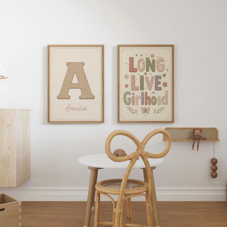 Puede incluir: Dos l&aacute;minas decorativas rectangulares en marcos de madera clara. La l&aacute;mina de la izquierda muestra una letra A grande con el nombre Amelia debajo. La de la derecha presenta el texto LONG LIVE Girlhood con motivos florales, corazones y mariposas.