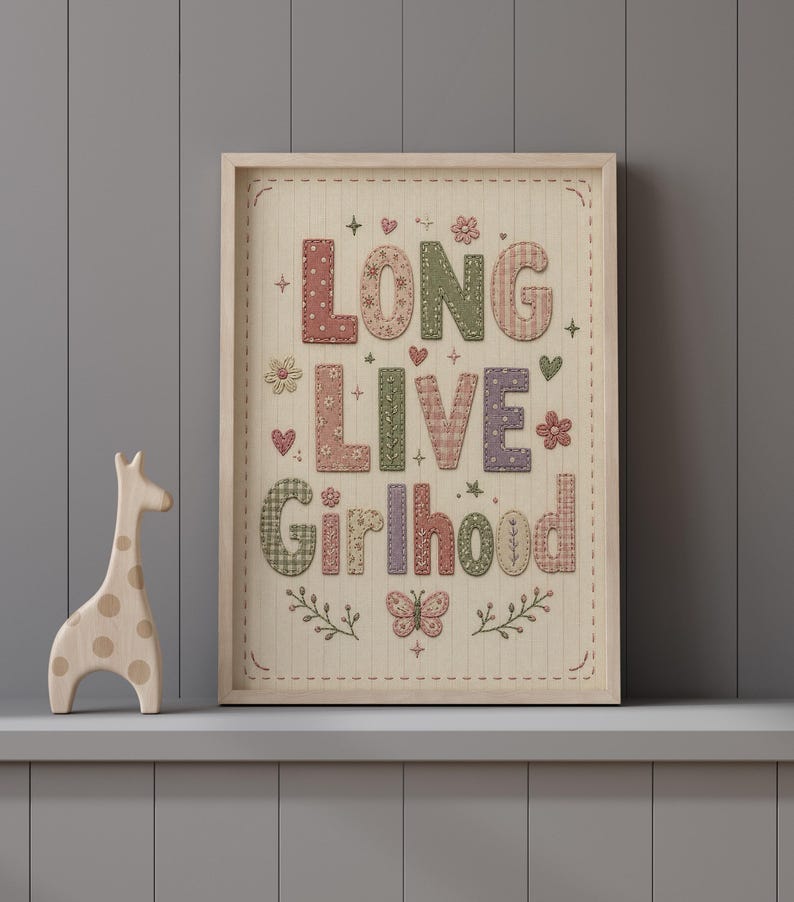 Puede incluir: Un cuadro decorativo con el texto "LONG LIVE Girlhood" en una tipograf&iacute;a estilo patchwork con colores suaves. El dise&ntilde;o incluye patrones florales, de cuadros y lunares con aspecto bordado, adem&aacute;s de corazones, estrellas, flores y una mariposa.