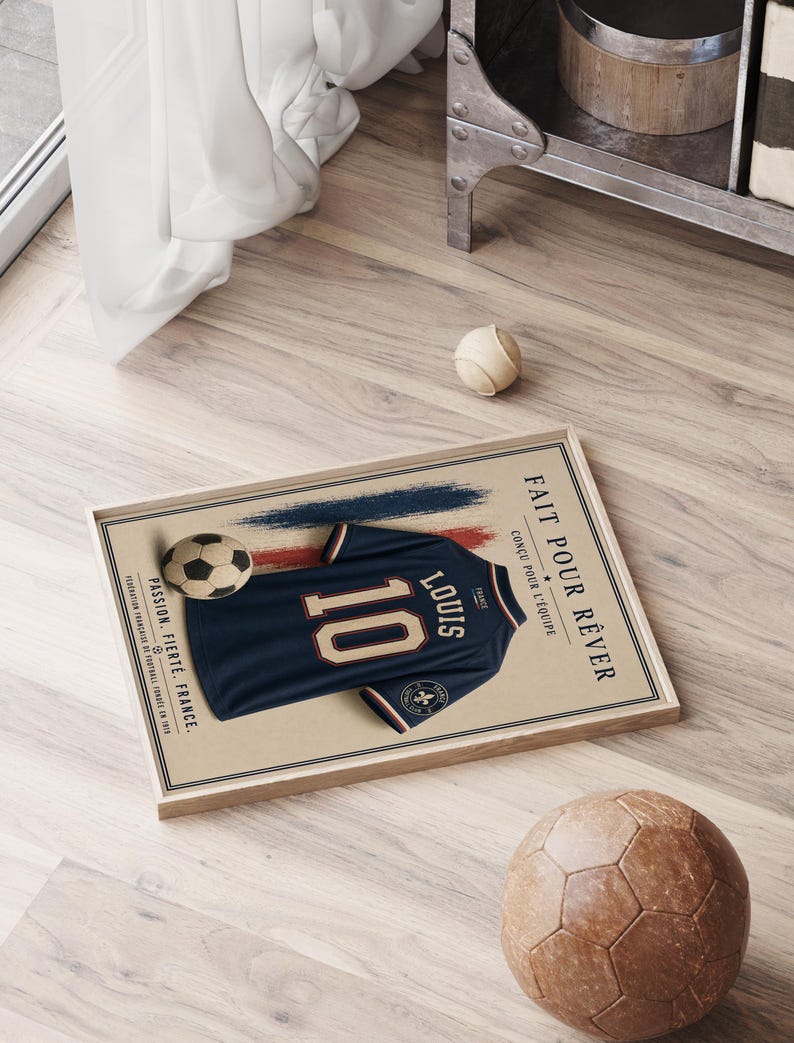 May include: A framed rectangular poster featuring a dark blue soccer jersey with the number 10 and the name Louis printed on the back. The design includes a soccer ball, red and blue brush strokes, and the text Fait pour r&ecirc;ver, Passion, Fiert&eacute;, France.