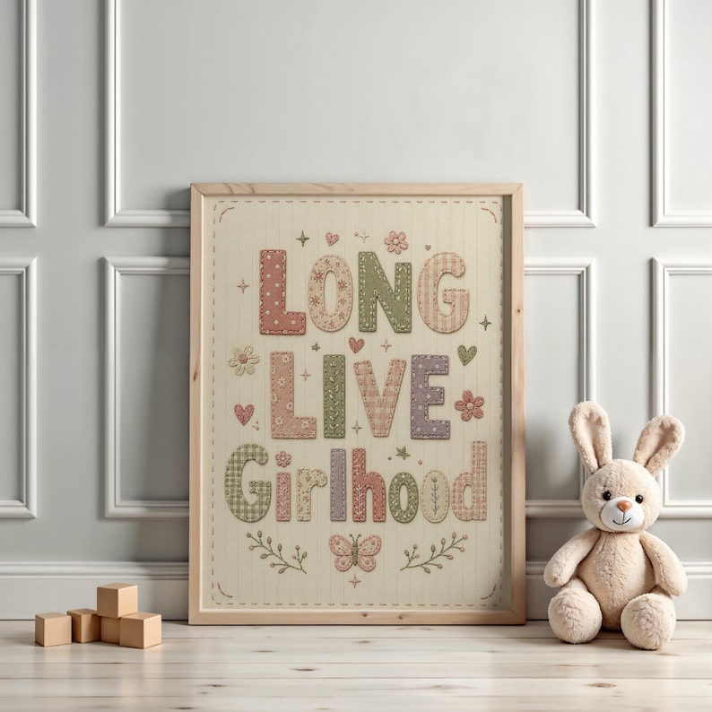 Puede incluir: Una l&aacute;mina de arte mural enmarcada con el texto LONG LIVE GIRLHOOD en letras may&uacute;sculas grandes, estampadas y multicolores. El dise&ntilde;o incluye peque&ntilde;as ilustraciones de flores, corazones, estrellas y una mariposa sobre un fondo crema.