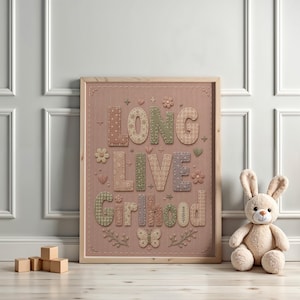 Puede incluir: Una l&aacute;mina enmarcada sobre un fondo rosa empolvado con el texto LONG LIVE GIRLHOOD en letras grandes estilo patchwork con varios patrones como cuadros vichy, flores y lunares, decorado con peque&ntilde;as flores bordadas y una mariposa.