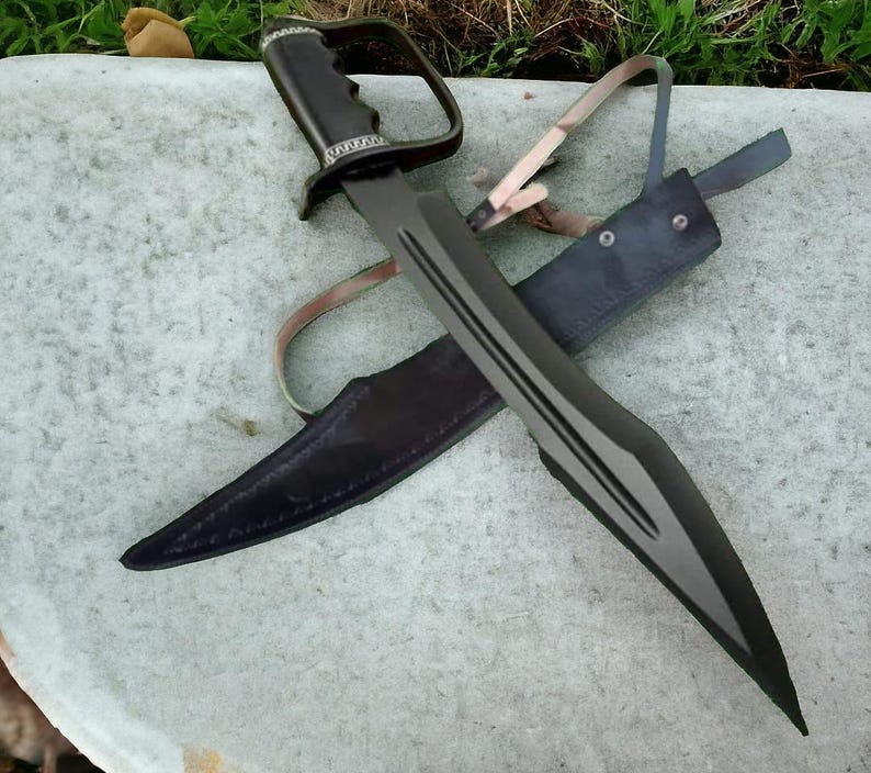 May include: A black sword with a unique handle and a matching sheath. The blade has a dark finish with three parallel grooves. The handle features a finger guard. The sheath is made of dark leather.