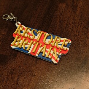 K&ouml;nnte beinhalten: Eine wei&szlig;e Keramik-Tasse mit schwarzem Henkel und dem Text "But First, Coffee" in schwarzer, fetter Schrift. Die Tasse steht auf einer wei&szlig;en Oberfl&auml;che.