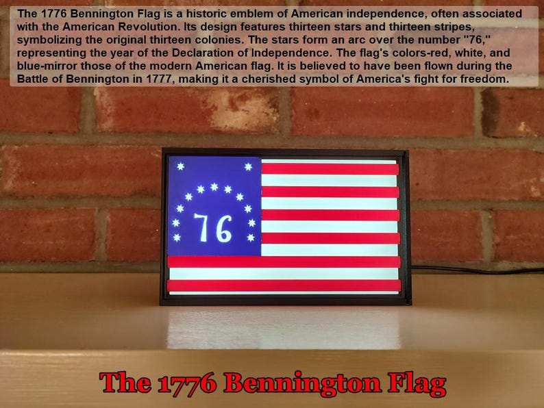 May include: A framed replica of the 1776 Bennington Flag, featuring thirteen white stars in a circle around the number "76" on a blue background. The flag has thirteen alternating red and white stripes.