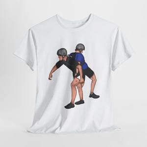 May include: White t-shirt with a graphic of two people wearing helmets and a harness, one person is piggybacking the other.
