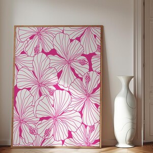 May include: A framed print featuring a white floral pattern on a bright pink background. The print features a repeating pattern of hibiscus flowers.