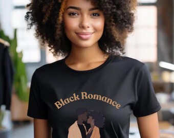 May include: Black t-shirt with the text "Black Romance Book Club EST. 2002" and an illustration of a couple kissing. The shirt is worn by a person with curly brown hair.