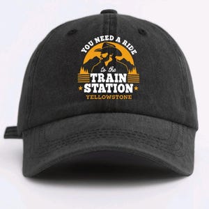 May include: Black baseball cap with a yellow and white graphic that says "You need a ride to the train station Yellowstone".