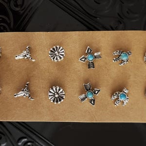 May include: Set of ten silver-toned metal buttons with turquoise stones. The buttons feature various designs, including stars, arrows, bull heads, and floral patterns.