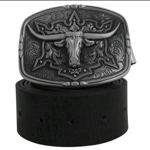 May include: A black leather belt with a silver-toned buckle featuring an ornate design of a steer's head with horns.