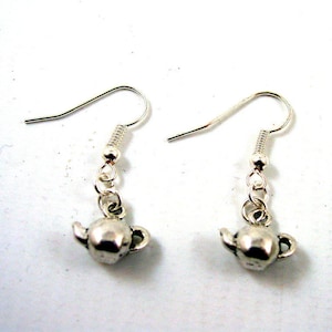 May include: Silver teapot dangle earrings with a silver hook. The teapot is a small charm hanging from a silver chain.