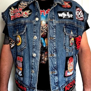Può includere: Un gilet in denim blu con varie toppe ricamate di gruppi musicali, tra cui Iron Maiden, W.A.S.P., AC/DC e Guns N' Roses. La giacca senza maniche presenta una chiusura a bottoni, due tasche sul petto, giromanica sfrangiati e borchie sul colletto.