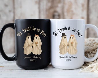 May include: Black and white ceramic mugs with a spooky wedding theme. Each mug features a ghost couple illustration with the text "Till Death do us Part", names, and the year 2025. The mugs are perfect for a Halloween or gothic wedding.