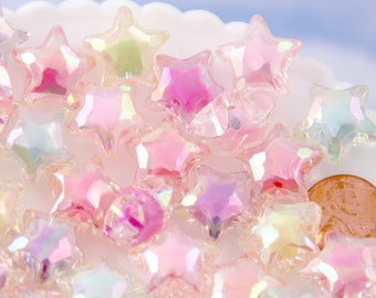 May include: A collection of iridescent pink, white, and blue star-shaped beads. The beads are made of glass and have a shiny, reflective surface.