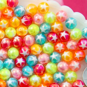 May include: A collection of colorful iridescent plastic beads with white star designs. The beads are approximately 1 inch in diameter.