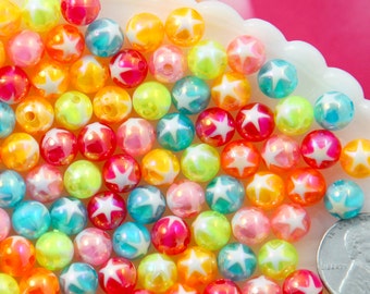 Puede incluir: Una colección de cuentas de plástico iridiscente de colores con diseños de estrellas blancas. Las cuentas tienen un diámetro aproximado de 2,5 cm.