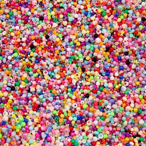 Könnte beinhalten: Eine große Auswahl an bunten Plastikperlen in verschiedenen Formen, darunter Herzen, Sterne und Kreise. Die Perlen sind perfekt zum Basteln von Schmuck, zum Herstellen von Armbändern oder zum Hinzufügen eines Farbakzents zu jedem Projekt.
