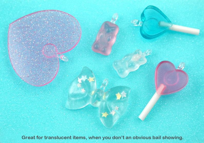 May include: Assortment of translucent pink and blue resin charms in various shapes, including hearts, butterflies, and gummy bears. The charms have a sparkly finish and are perfect for jewelry making or crafting.