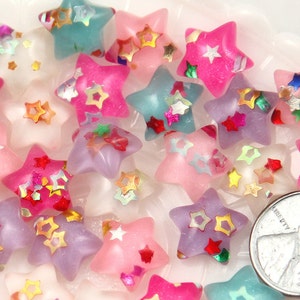 May include: Assortment of colorful star-shaped beads with glitter accents. The beads are translucent and have a variety of colors, including pink, blue, purple, and white.