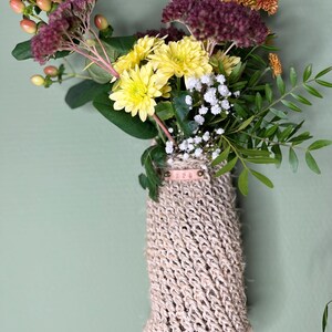 Peut inclure: Un pot suspendu en corde de fibre naturelle avec une étiquette en cuir qui dit "APQ". Le pot est rempli d'un bouquet de chrysanthèmes jaunes et blancs, de fleurs bordeaux et de petites fleurs blanches.